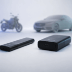 Tracker GPS Invoxia Pro Max posé sur fond sombre, objet connecté compact noir de 70 grammes