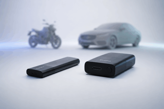 Tracker GPS Invoxia Pro Max posé sur fond sombre, objet connecté compact noir de 70 grammes